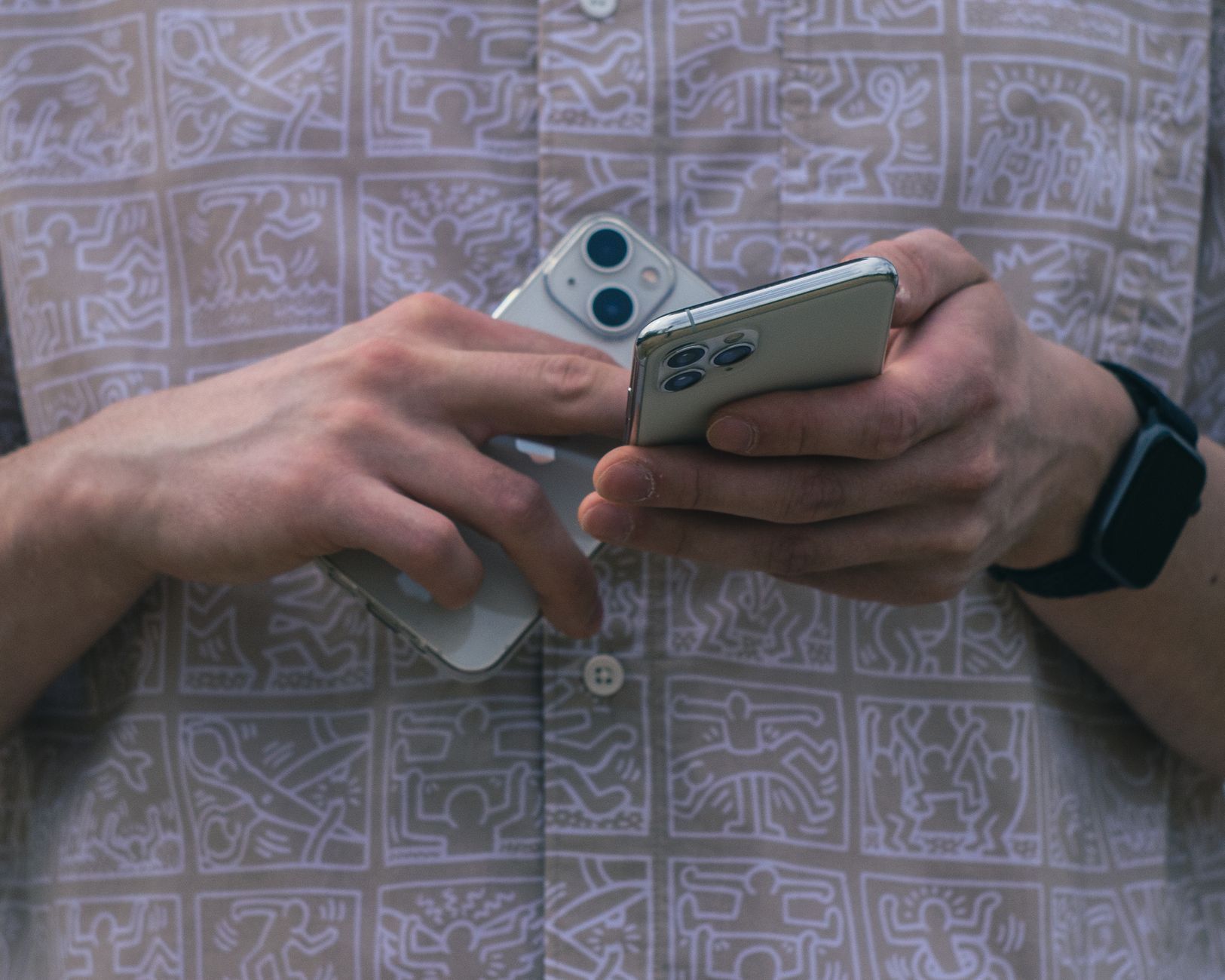 Traveller holding two smartphones side by side while moving accounts to a new phone number abroad